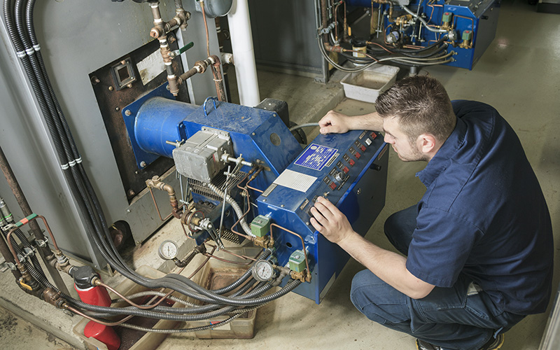 A service technician works on Boiler